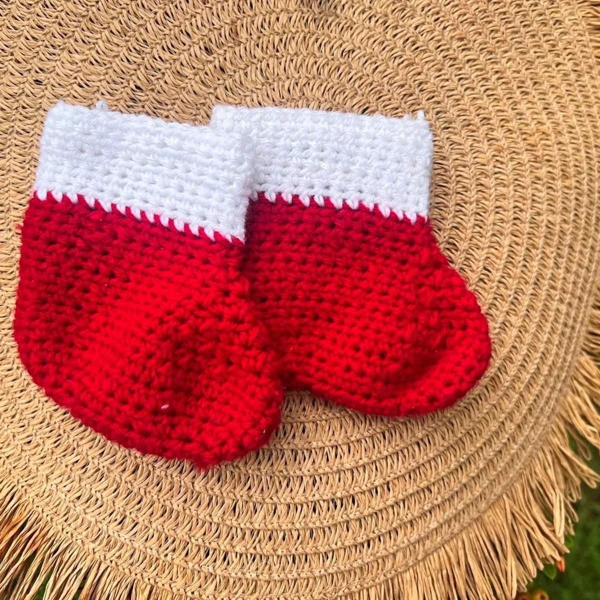 HOME Red and white crochet baby mittens on a woven straw mat